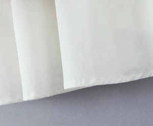 Vue macro détaillée du tissu blanc plissé et de la couture de l'ourlet de la robe à manches