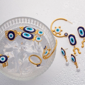 Detailed view of Turkish Evil Eye jewelry set with gold ring, earrings, and bracelet