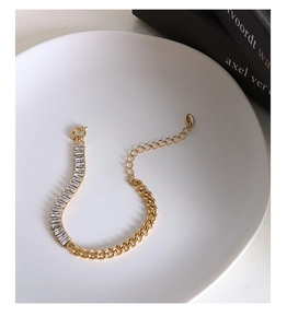 Detail of gold Cuban chain bracelet with rectangular zircon inlay and 925 engraving tag