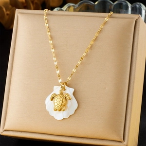 Detail of 18K gold turtle pendant with shell base resting in a jewelry box