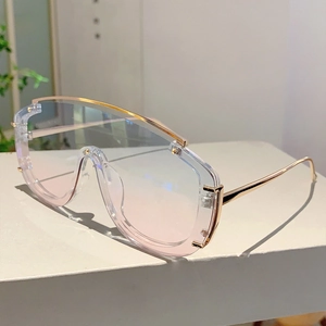Detail of light pink oversized shield sunglasses with slim gold metal frame and bridge