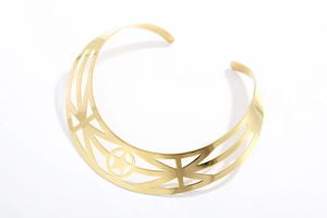 Macro detail of gold metal choker necklace with hollow star pattern and geometric lines