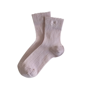 Pink ballet-style ribbed socks with delicate white bow embroidery on pure white background
