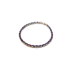 Elegant geometric silver bracelet with inlaid purple cubic zirconia on a white background