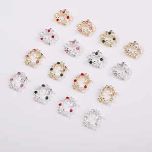 Détail de charmes pour ongles en forme de couronne de Noël avec perles et strass