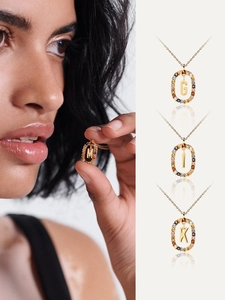 Detail of gold letter necklaces M G I K with colorful crystals on model and still life