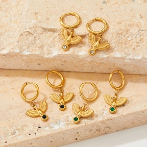 Detail view of gold eagle hoop earrings featuring white black and green zircon stones