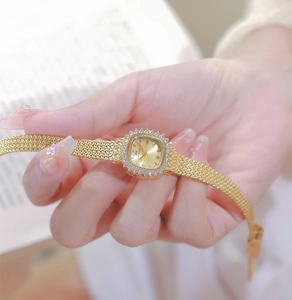 Macro shot of gold square watch featuring a rhinestone bezel and mesh bracelet