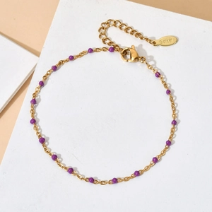 Detail of gold stainless steel chain with purple enamel beads and lobster clasp closure