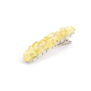 Detail of yellow natural crystal stones on a silver metal duckbill hair clip base
