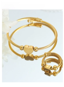 Detail of twisted cable gold heart jewelry set including an open bangle and matching ring