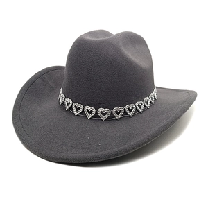 Détail d'un chapeau de cow-boy gris foncé en laine avec une bande de cœurs strass