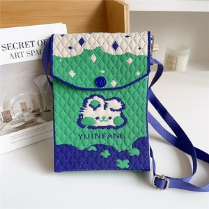 Close-up of knit crossbody bag featuring abstract mountain scenery and adjustable strap