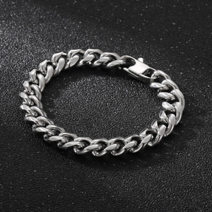 Detail of silver polished Cuban link bracelet with lobster clasp on black background