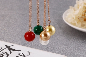 Détail de cinq pendentifs sphériques colorés sur colliers en or rose dans un lot chic