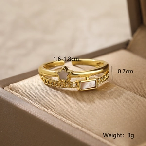 Detail of gold-plated double-layer ring with star inlay, shell stone, and chain texture