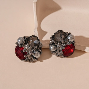 Close-up of vintage baroque stud earrings with red gemstones and grey pearls