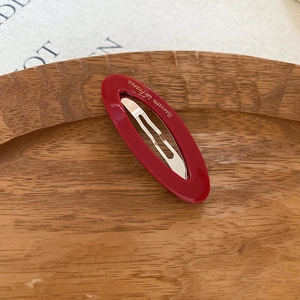 Detail view of the red acetate oval hair clip with gold Barrette La France text