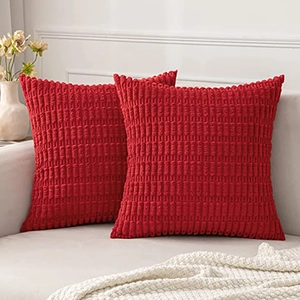 Close-up of red corduroy pillow covers showing detailed pineapple grid texture on sofa