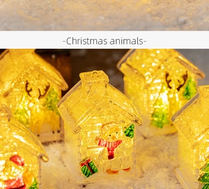 Close-up of glowing Christmas house ornaments featuring reindeer and snowman patterns
