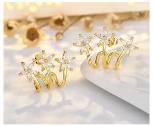 Macro view of gold-plated flower stud earrings with sparkling white cubic zirconia