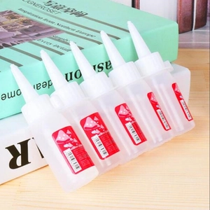 Five bottles of super glue with red labels and pointed caps for DIY wood crafts
