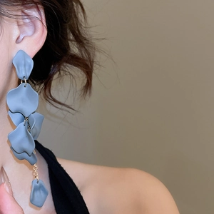 Close-up of Morandi blue acrylic petal tassel earrings worn by a female model