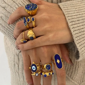 Gold stainless steel ring set with lapis lazuli and evil eye charm on female model