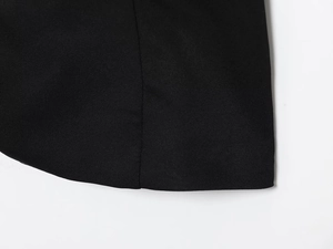 Close-up of the precise stitching and smooth black fabric texture on the vest hemline
