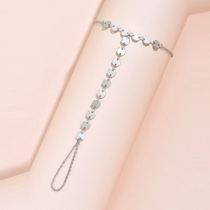 Detailed close-up of a silver metal disc chain bracelet worn on a model's arm