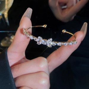 Macro shot of a gold-plated open bangle with sparkling sun and moon zircon settings