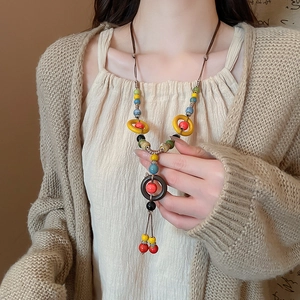 Close-up of handmade ethnic ceramic bead necklace with hollow pendant on a model