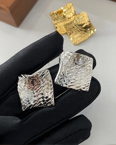 Detail showing the intricate woven texture and metallic luster of rhombus stud earrings