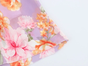Detail of purple floral chiffon fabric with delicate stitching and airy texture