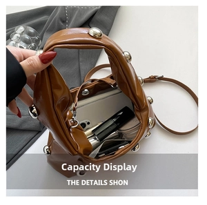 Interior view of brown studded tote bag showing spacious storage for phone and cosmetics