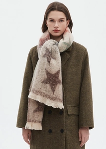 Detail of star jacquard pattern and fringe on beige gradient scarf worn with coat