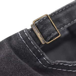 Close-up of vintage bronze metal buckle and stitching on washed cotton baseball cap