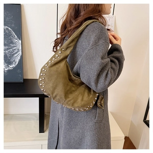 Detail of olive green canvas hobo bag with silver studs and wide shoulder strap