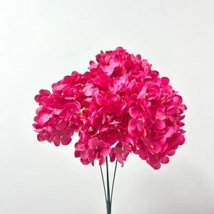 Close-up of vibrant deep pink faux hydrangea flower head with realistic green stems