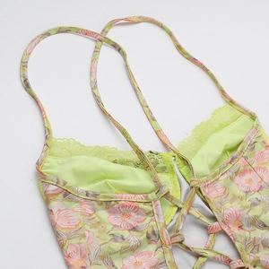 Détail des bretelles croisées et dentelle sur la robe d'été verte à fleurs