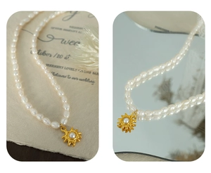 Detail view of French vintage freshwater pearl necklace with golden sun pendant on wedding prop