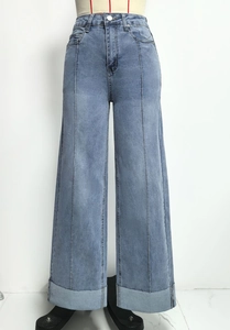 Detail van lichtblauwe jeans met hoge taille, middennaad en omgeslagen broekspijp