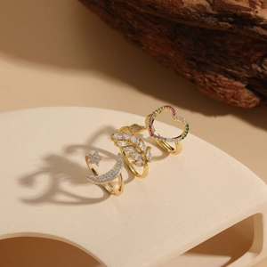 Detailed view of 14K gold-plated rings set with star, moon and leaf patterns and zircons