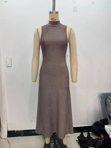 Dettaglio del tessuto a maglia glitterata su un abito midi senza maniche a collo alto