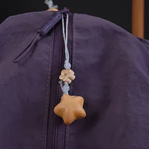 Detail einer lila Nylontasche mit einem chinesischen Stern- und Blumenanhänger