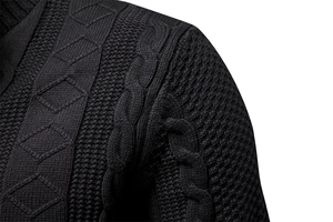 Dettagli macro della maglia a trecce nere e texture a rombi sul cardigan da uomo