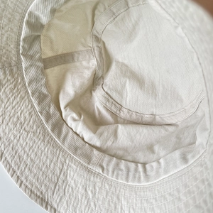 Detail view of reinforced stitching and waffle texture on the nylon sun bucket hat