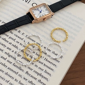 Minimalist twisted rope rings in gold and silver finish placed on an open book