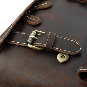 Macro shot of vintage dark brown crazy horse leather texture and brass buckle detail