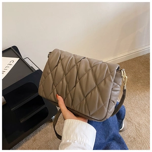 Detailed close-up of dark taupe quilted crossbody bag with elegant gold chain strap